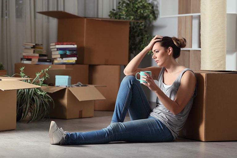 Woman in house letting with packing boxes